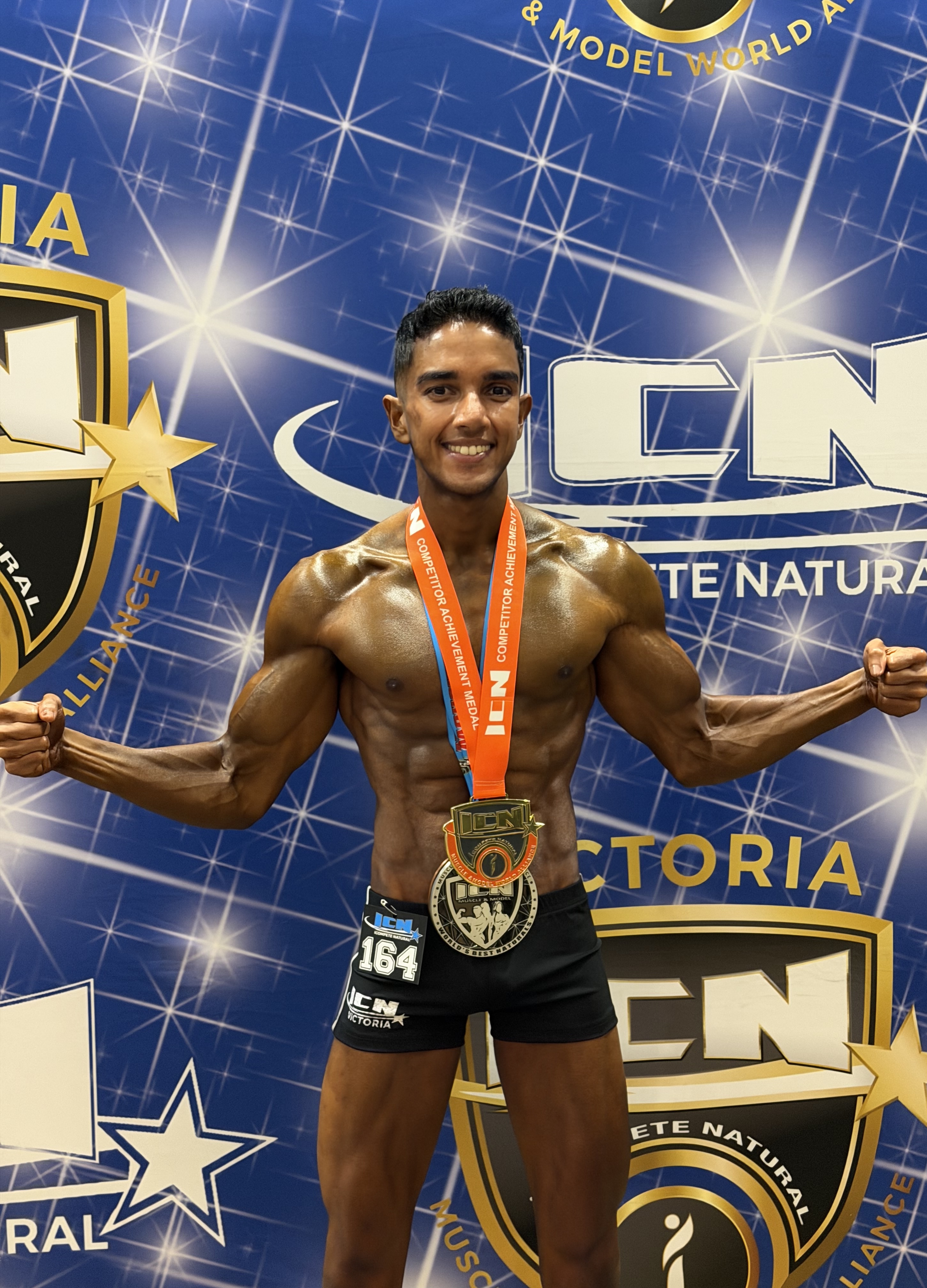 Side stage pose displaying muscle definition and leanness